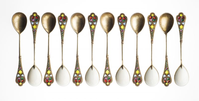 12 golden spoons lined up in a row