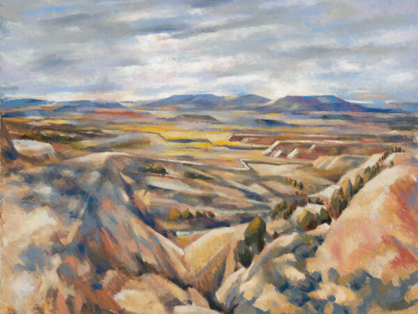 A road leads down from a mesa to the valley below.