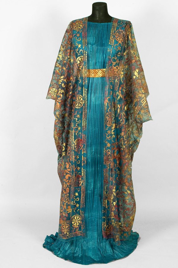Photo of a paper dress that looks like real fabric in ruffled teal with a gold belt and a sheer gold overlay shawl with a decorative motif