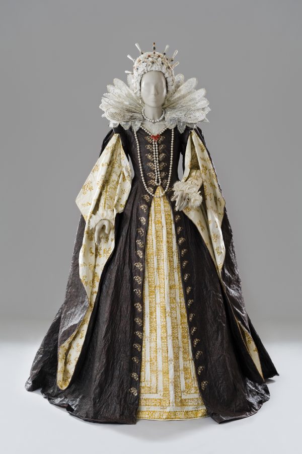 Photo of a life-size woman's royalty dress with an elaborate collar, pearls and a dress of brown and white with gold accents made entirely of paper and painted with acrylic