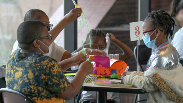 Four children around a table with artmaking supplies