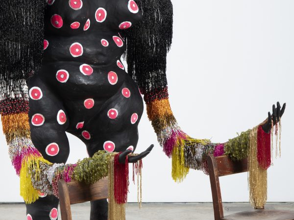 Detail photo of the sculpture by vanessa german showing part of a figure and hands outstretched