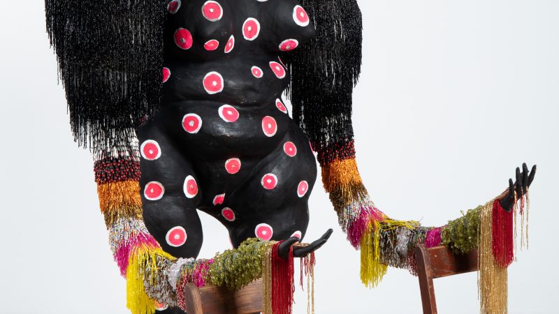 Detail photo of the sculpture by vanessa german showing part of a figure and hands outstretched