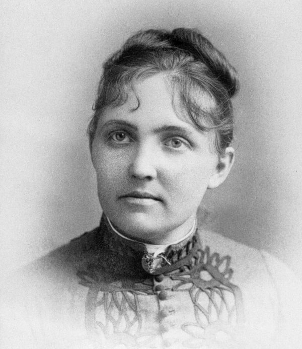 Black and white photograph of a woman with a lace collar and her hair up in a bun