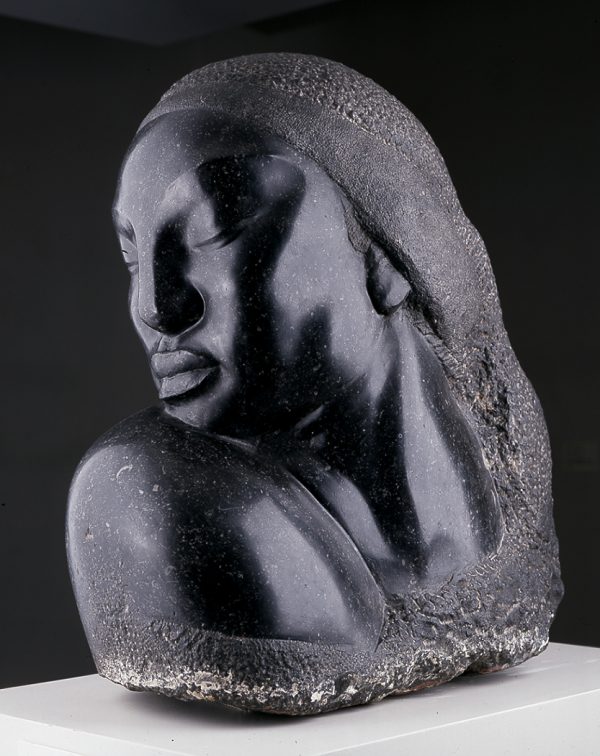 A massive head with eyes closed is turned toward the subject's right shoulder.