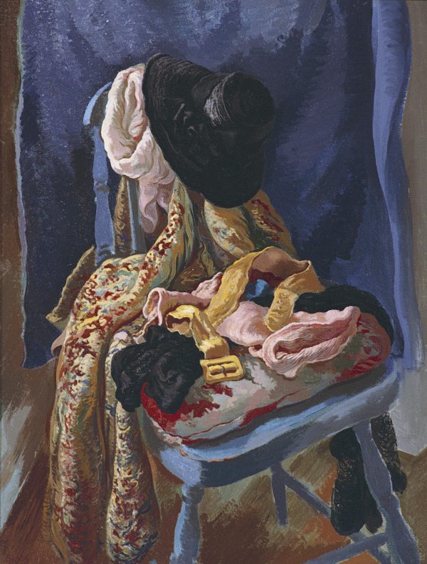 A blue chair is heaped with clothes before a blue cloth in the background.