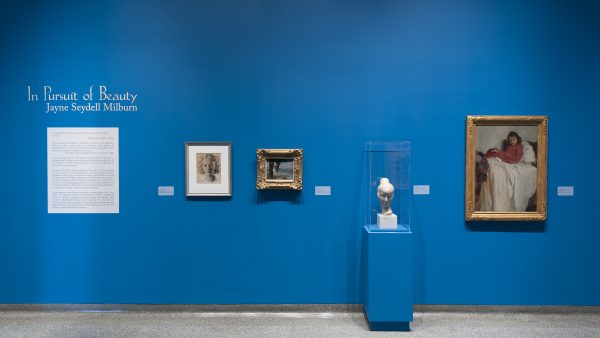 Interior view of galleries with paintings on the wall and a sculpture on a pedestal