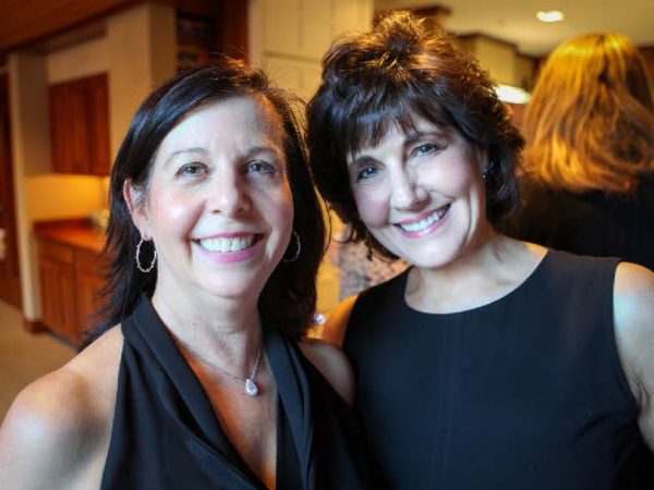 Two women looking at the camera and smiling