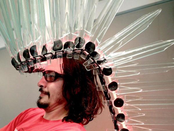 Headshot of Rory Erler Wakemup. He's wearing a native american headdress made out of glass.