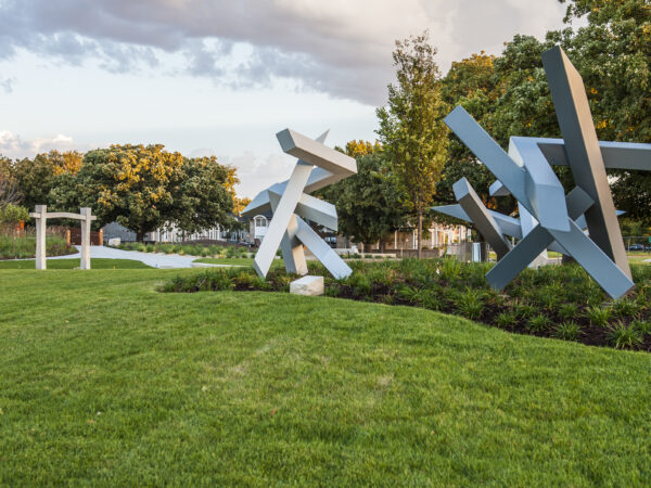 Photo of three sculptures in the Art Garden surrounded by green grass and plantings