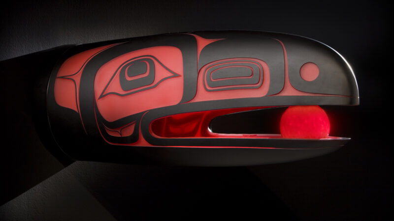 Photo of a glass work of art featuring a raven with the sun in its mouth