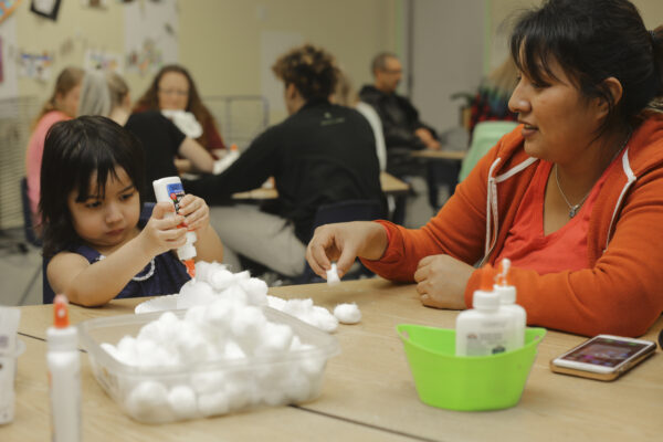 Mother and daughter at a table with art supplies.