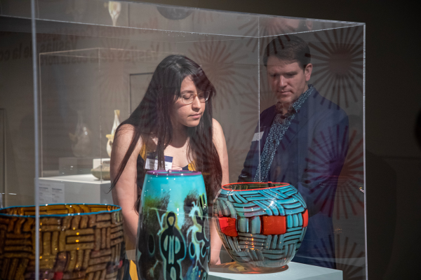 Two visitors looking through a glass case in the exhibition