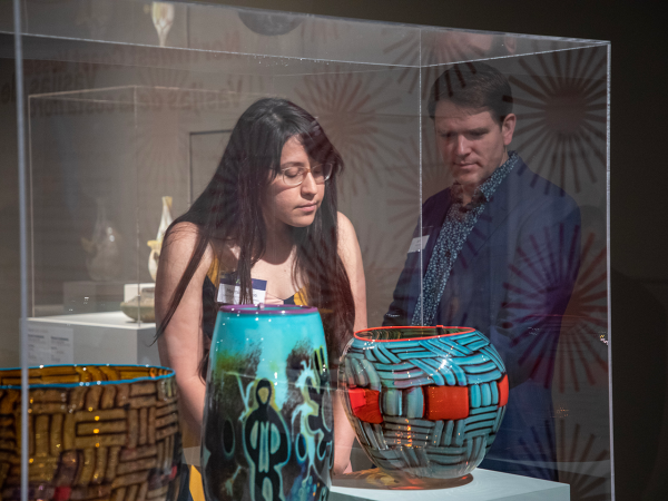 Two visitors looking through a glass case in the exhibition 