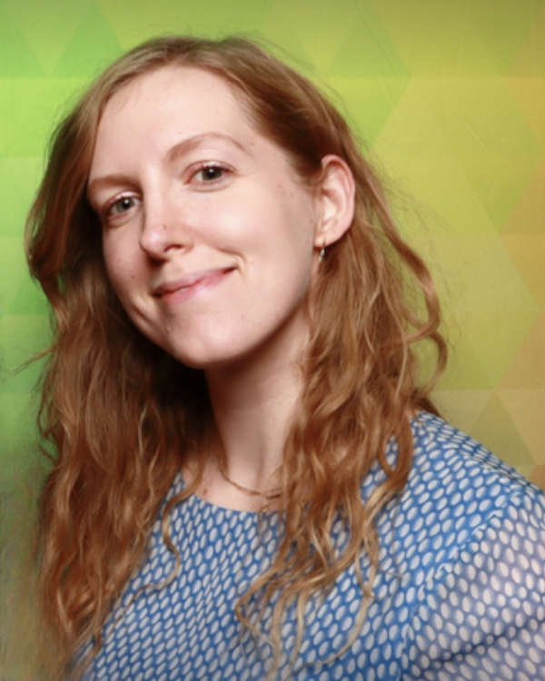 Headshot of Ellen Jones. Redhead, wearing a blue polka-dotted blouse.